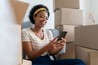 a woman sitting on a chair holding a cell phone