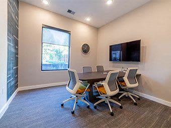 A conference room with a table and four chairs at The Foundry Apartments , South Bend, IN, 46617