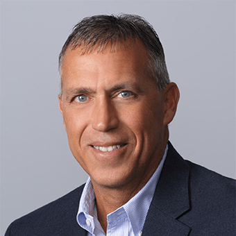a man in a suit and tie smiles at the camera
