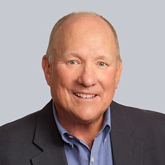 a man in a suit and tie smiling at the camera