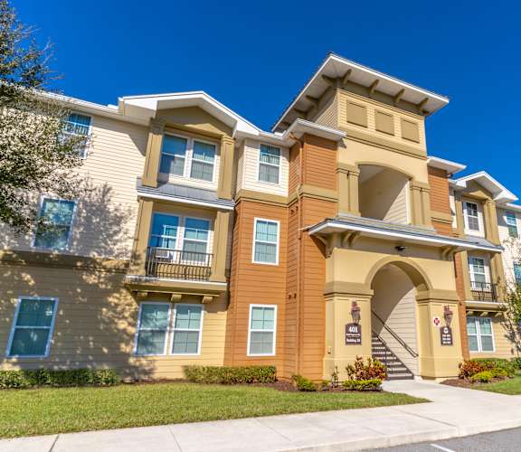 an apartment building with a sidewalk in front of it