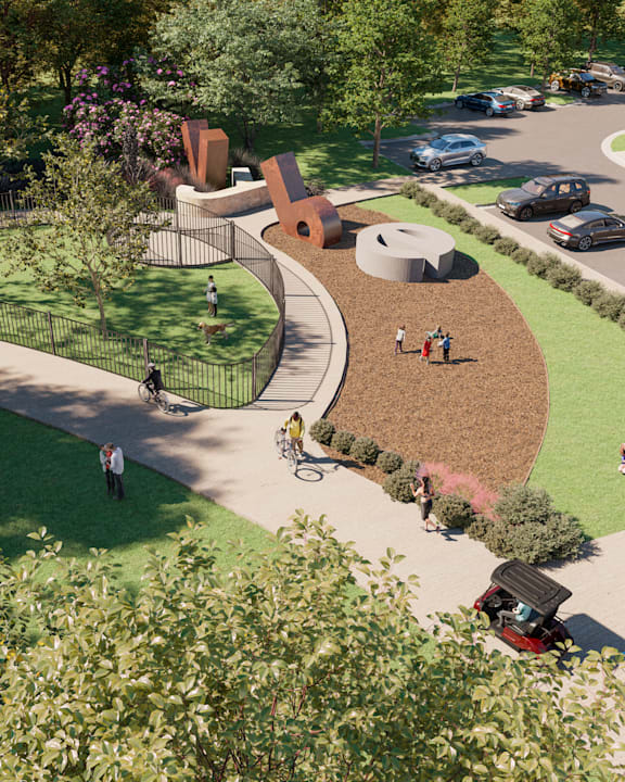 A park with a walking path and people walking and sitting on the grass.