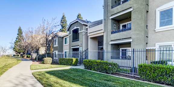 a man and woman with a little girl holding balloons and a bag at AGAVE APARTMENTS, California, 95757