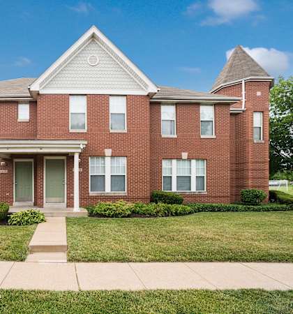 a brick house with a sidewalk in front of it