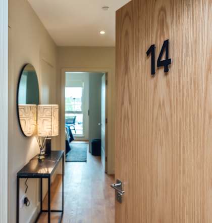 a wooden door with the number 14 on it and a table with a lamp and a mirror