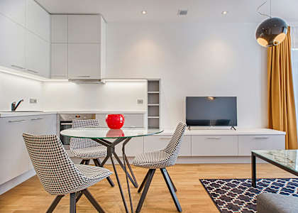 A modern kitchen with a glass table and chairs.