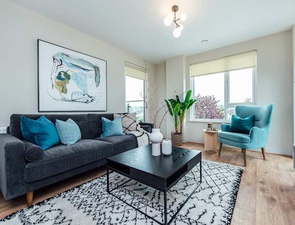 a living room with a gray couch and blue chairs