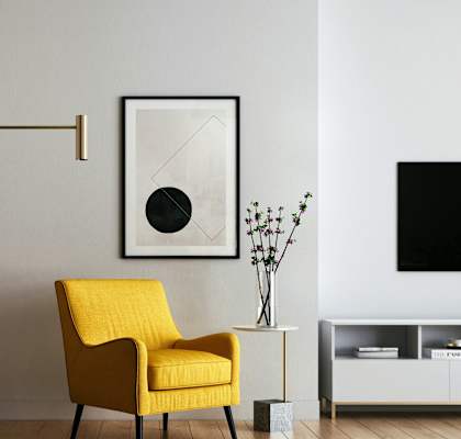 a yellow chair in a living room with a lamp and a television