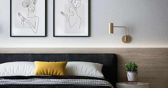 a bedroom with a bed and two paintings on the wall
