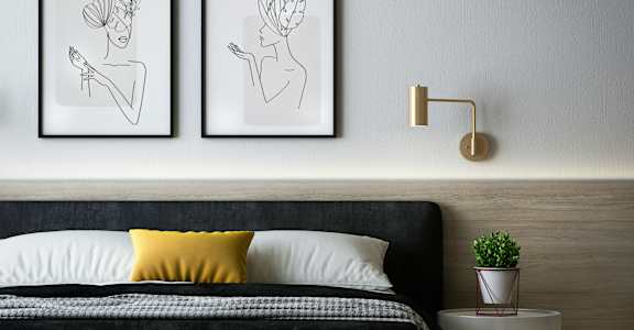 two drawings of hands on a wall in a bedroom