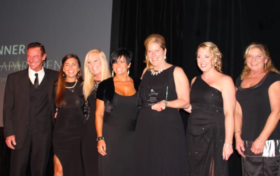 a group of women in black dresses posing for a picture