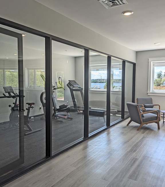 a home gym with glass sliding doors and a table with chairs