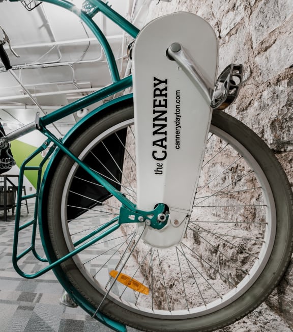 a green bike parked against a brick wall
