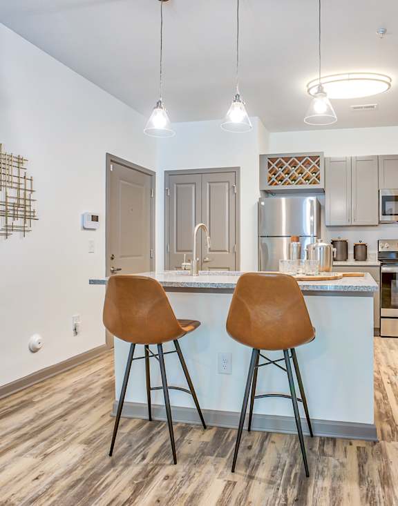 A kitchen with a bar area and two chairs.