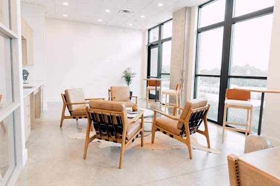 a table and chairs in a room with large windows