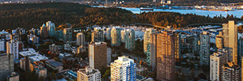 A cityscape with buildings and a body of water in the distance.