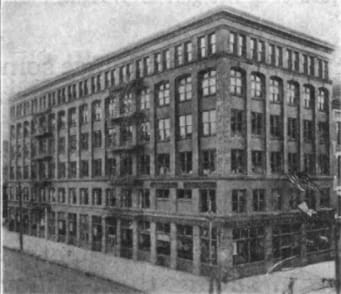 A black and white photo of a large building with many windows.