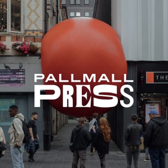 a giant red ball on the side of a street