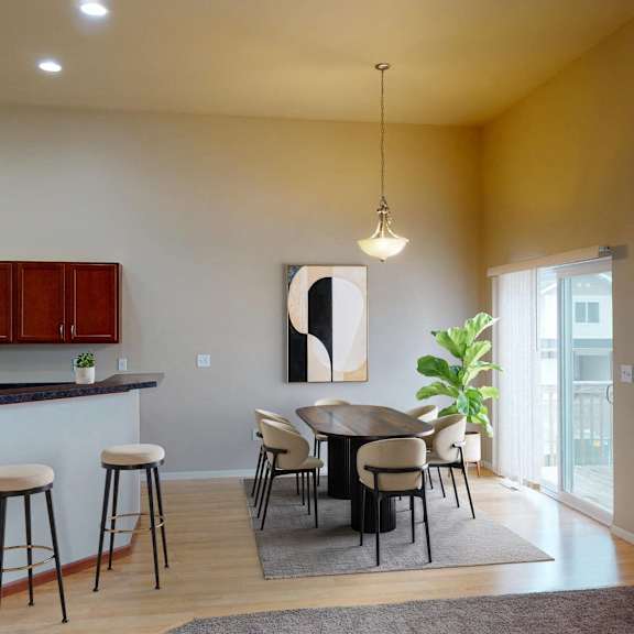 A kitchen with a bar and chairs.