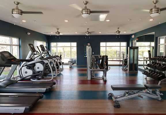 a gym with treadmills and other exercise equipment at The Crest at Laurel Canyon Apartments, Naples, Florida