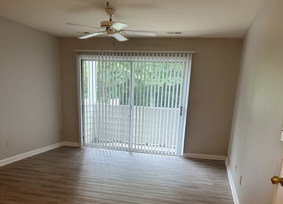 an empty room with wood floors and balcony