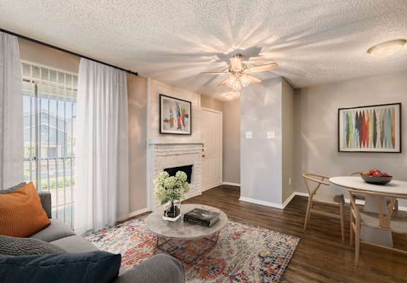 A living room with a grey couch, a rug, a fireplace, and a painting on the wall.