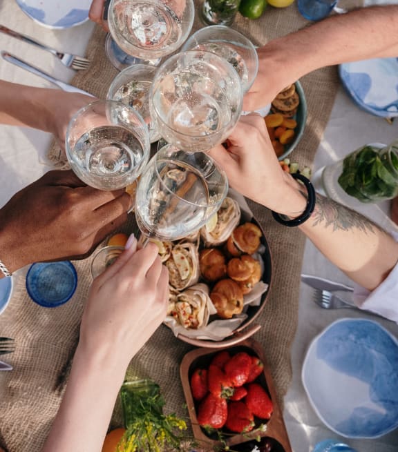 a group of people sitting around a table with wine glasses