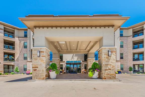 The entrance to a building with a stone pillar and a covered walkway.