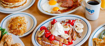 A breakfast spread with pancakes, eggs, and fruit.