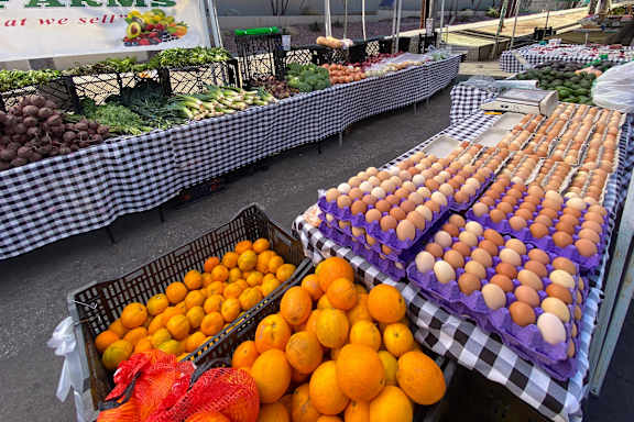A market with a sign that says Farms at the top.