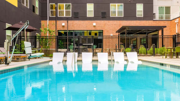 Swimming pool at Stella Apartments with in-pool chaise lounges