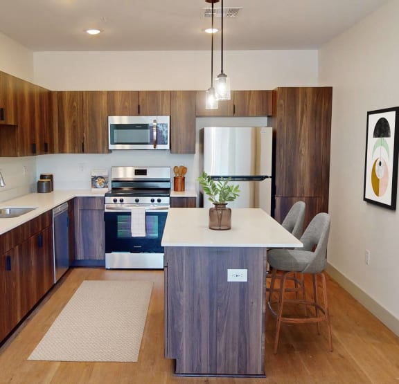 a kitchen with wood floors and wooden cabinets
