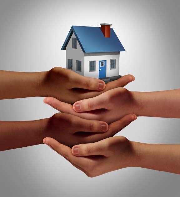 a family holding a house in their hands