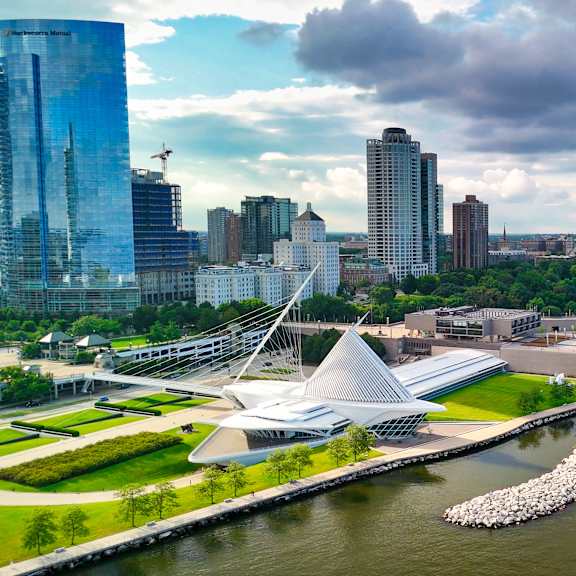 A modern building with a unique design is situated next to a body of water.