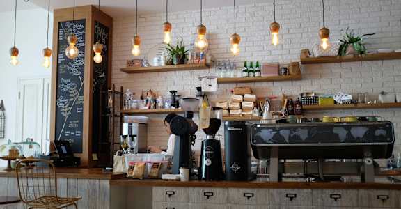A coffee shop with a barista working behind the counter.