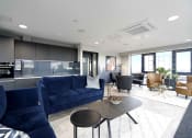 Thumbnail 8 of 19 - a living room with blue couches and a coffee table