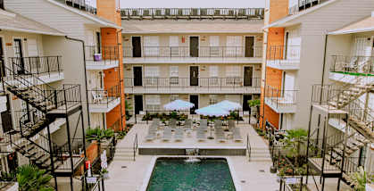 A pool surrounded by balconies and lounge chairs.