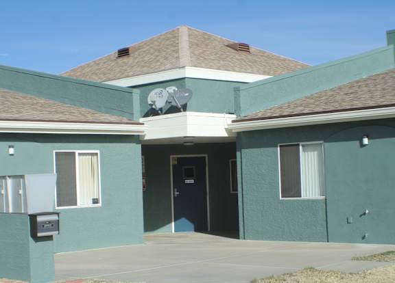 A green house with a satellite dish on the roof.