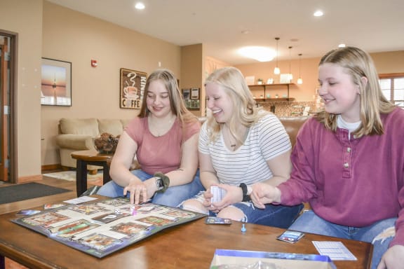 three girls sitting around a table playing a board game at Boulder Ridge, Minnesota, 55811