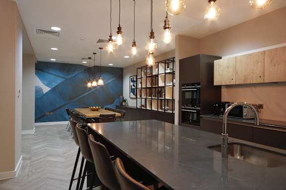 a kitchen with a large island and chairs in front of a table and a sink