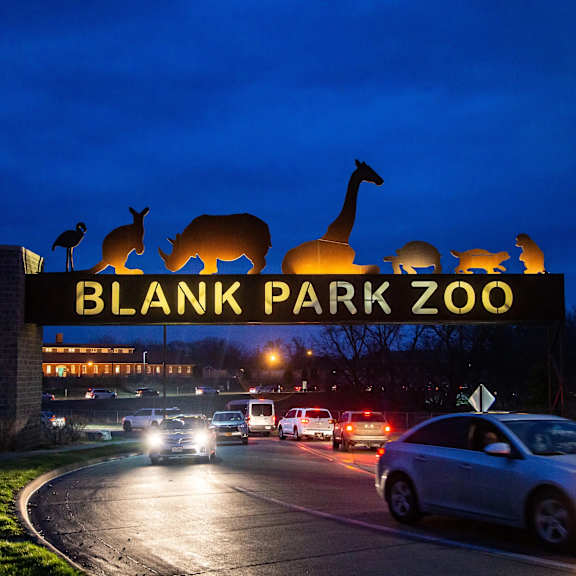 A sign for Blank Park Zoo is lit up at night.