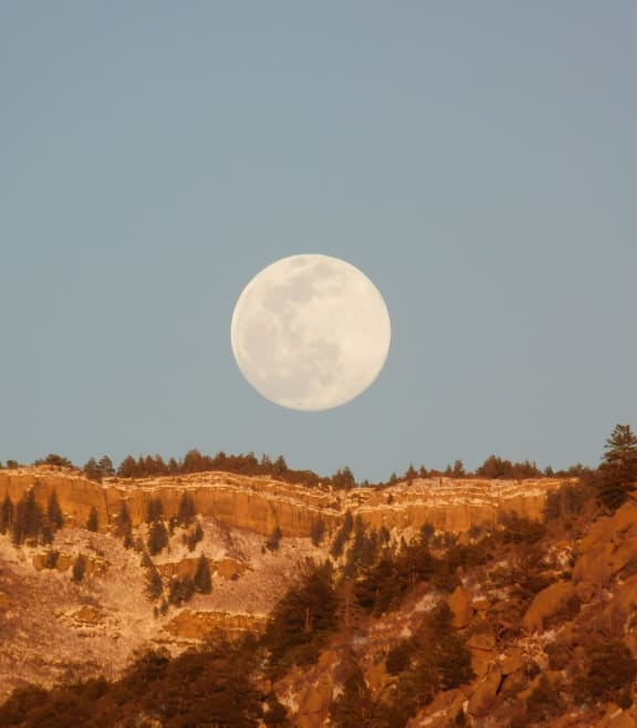 a full moon rises over the desert at Links at High Resort, Rio Rancho, NM, 87124
