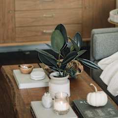 a living room with a coffee table and a dresser in the background