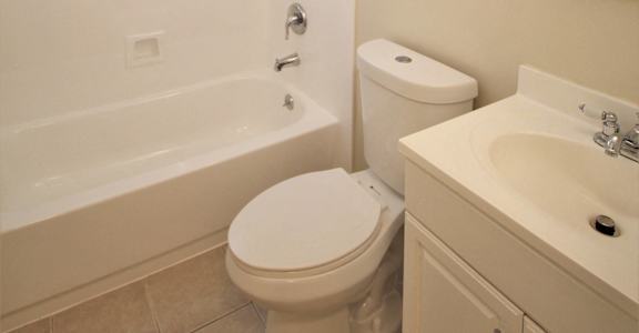 a bathroom with a toilet and a tub and a sink