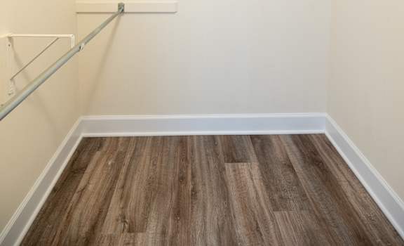 an empty room with white walls and a wood floor