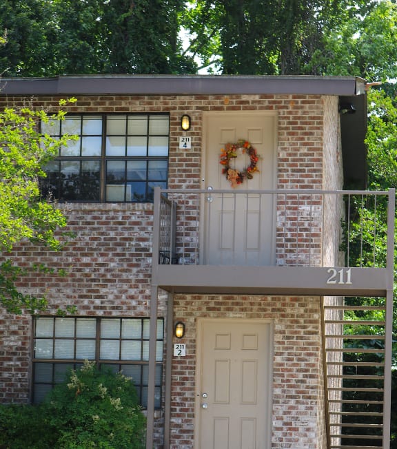 the front of a brick house with a white door and a wreath