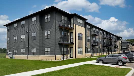 A modern apartment building with a car parked in front.