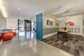 Building Entryway with Mail Room, Geometric Abstract Paintings on Wall, and Red/Orange Seating