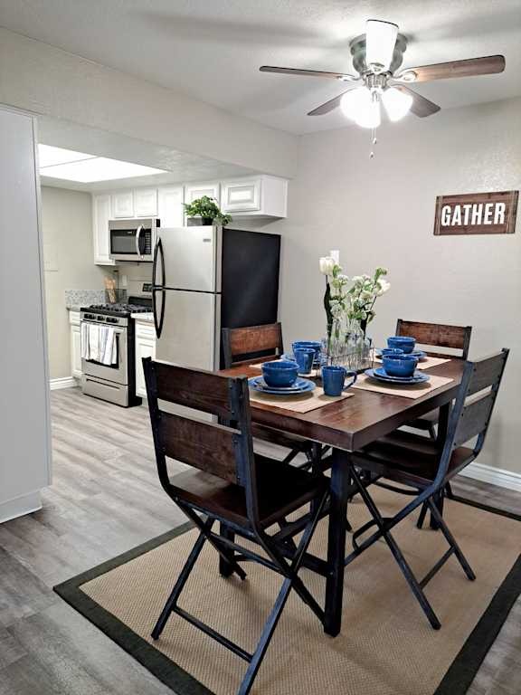 A dining room with a table set for two and a sign that says