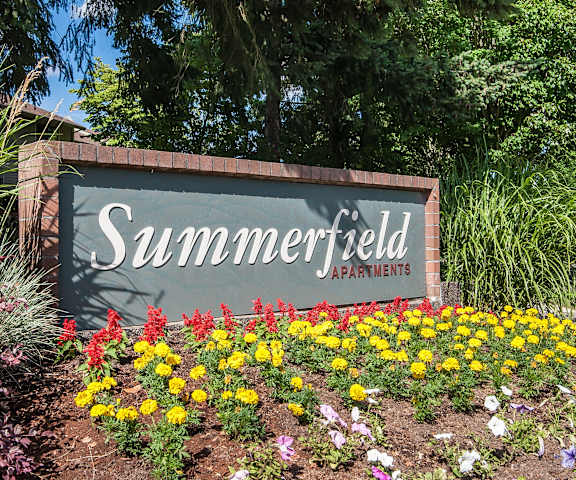 a sign apartments with flowers in front of it